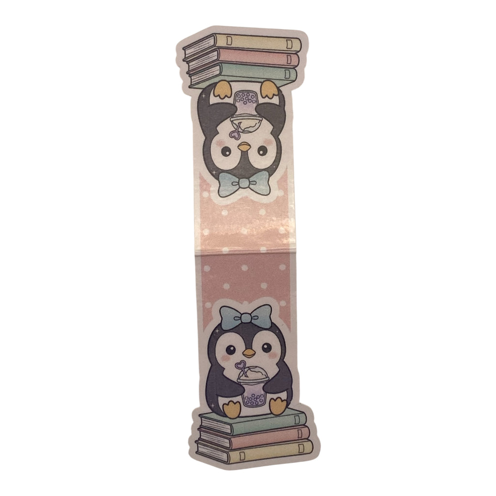 A die-cut sticker featuring a cute cartoon penguin holding books, shown on a plain white background.