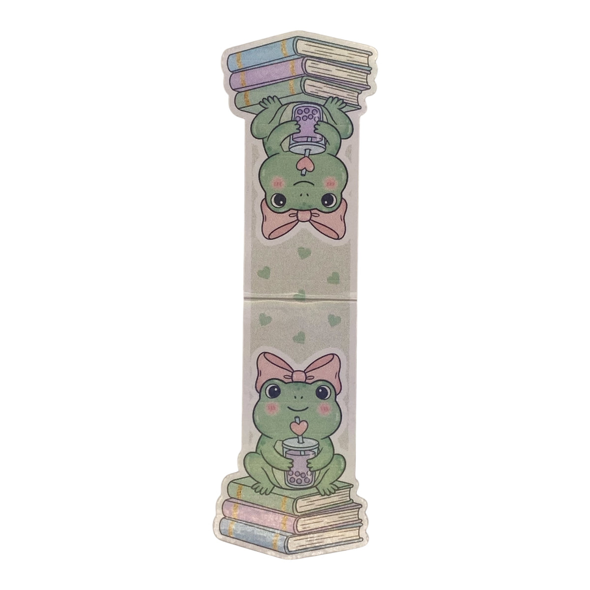 A long, narrow decorative magnetic bookmark item with a light beige background and printed cartoon frogs holding books and a cup, shown on a plain white background.