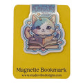 A cute magnetic bookmark of a blue and white cat reading a book, mounted on a yellow backing card labeled 'Magnetic Bookmark' with the website 'www.studiovibedesigns.