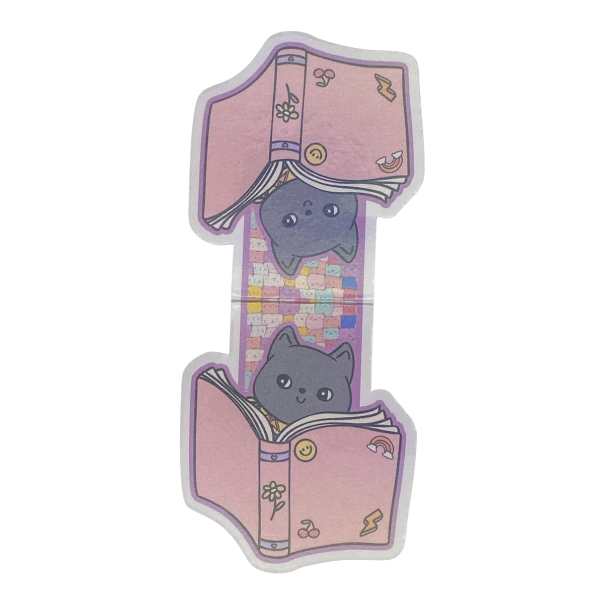 A die-cut magnetic bookmark featuring a whimsical design of two gray cats peeking out from pink books on a pastel patterned background, isolated on a white background.