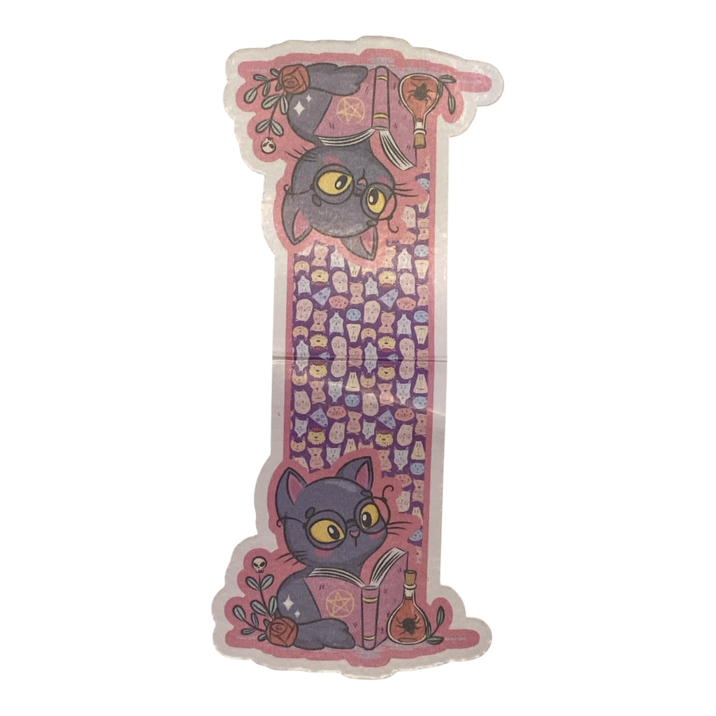 A die cut magnetic bookmark featuring a pink and purple magical theme with cartoon cats, stars, and occult symbols, shown on a plain white background.