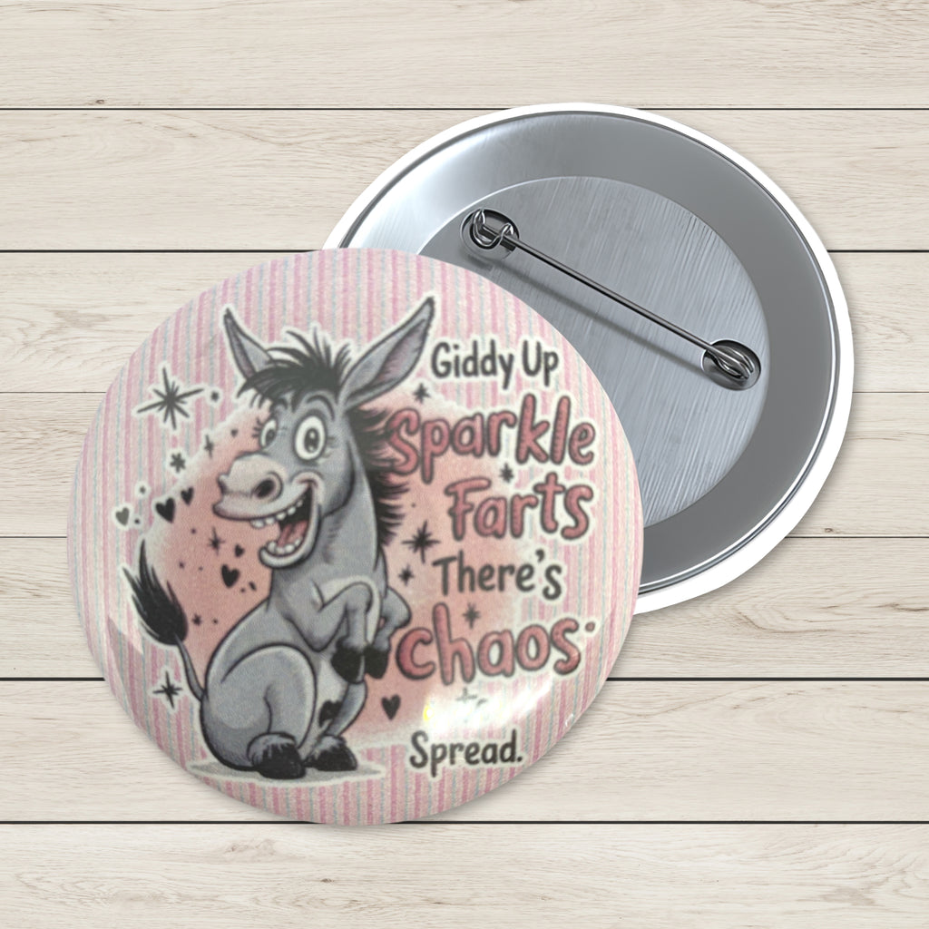 Two round pinback buttons displayed on a light wood background. The front button features a cartoon donkey and the text 'Giddy Up Sparkle Farts There's Chaos Spread.